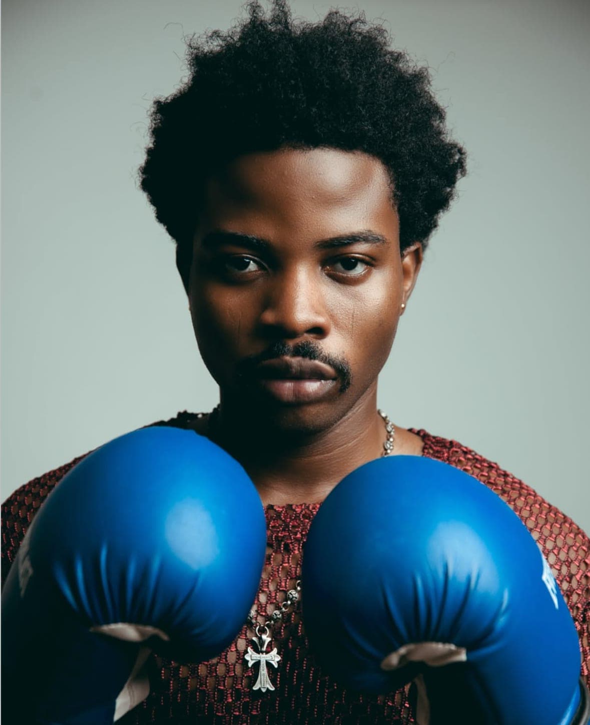 Close portrait with blue boxing gloves and a mesh top