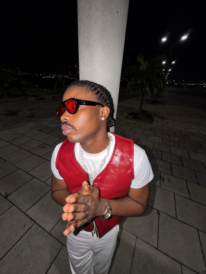 Red leather vest, white tee and red-lens sunglasses at night