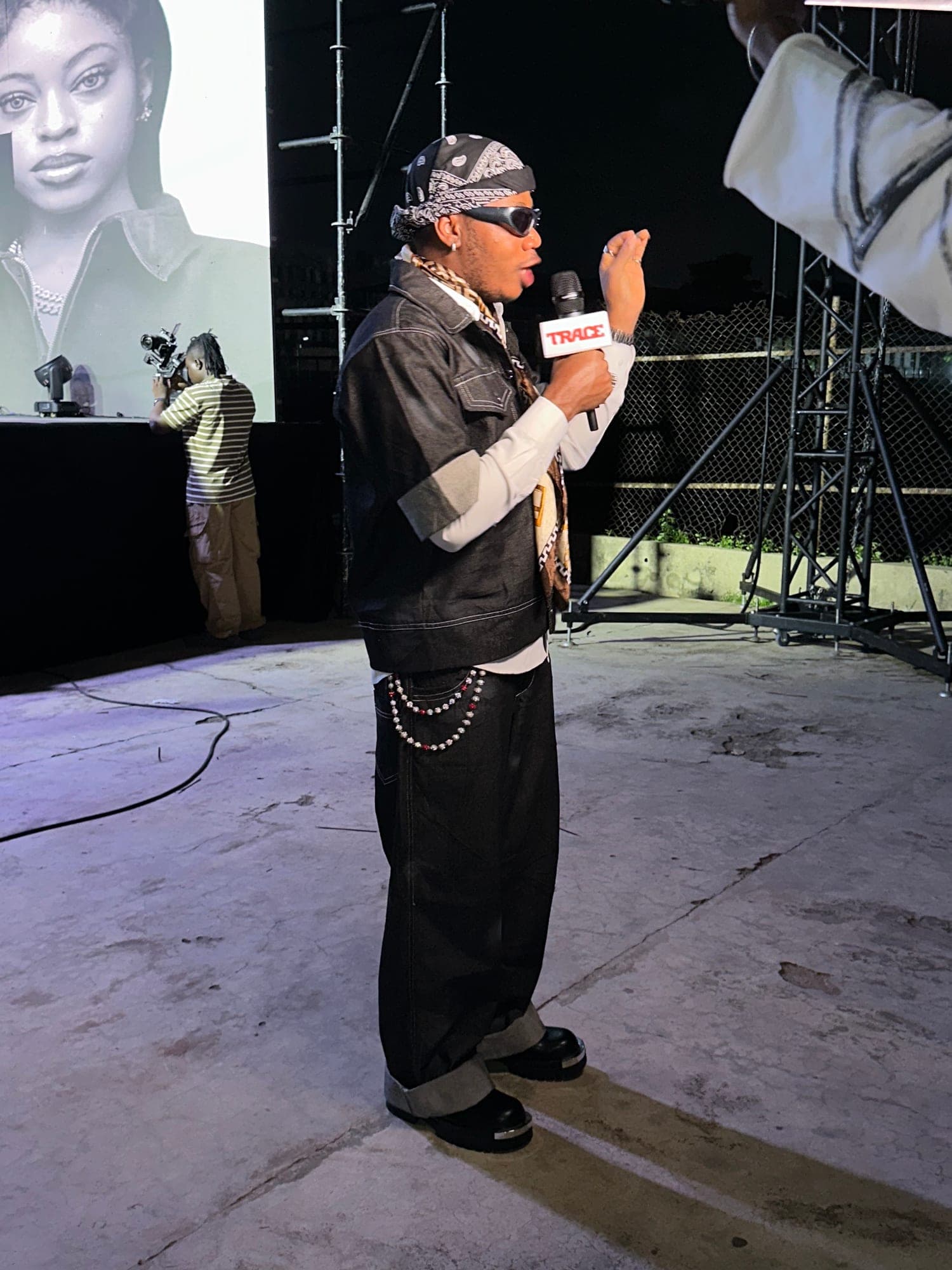 Host speaking into a microphone in a bandana and leather vest